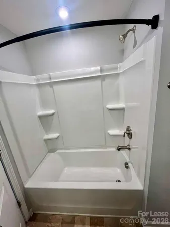 a bathroom with a shower and a bath tub