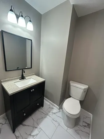 an empty room with wooden floor closet and windows