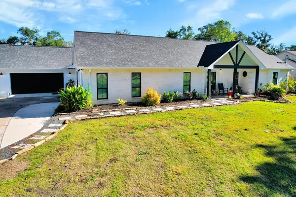 a view of house with yard and outdoor seating