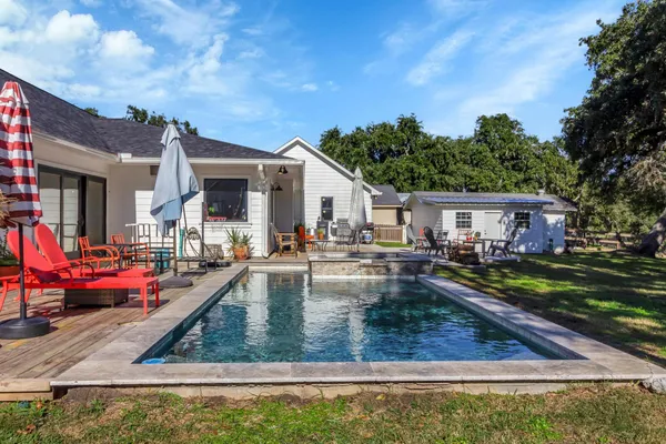 a view of a house with backyard swimming pool and sitting area