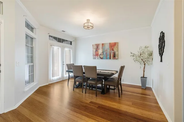 an empty room with wooden floor fireplace cabinet and windows