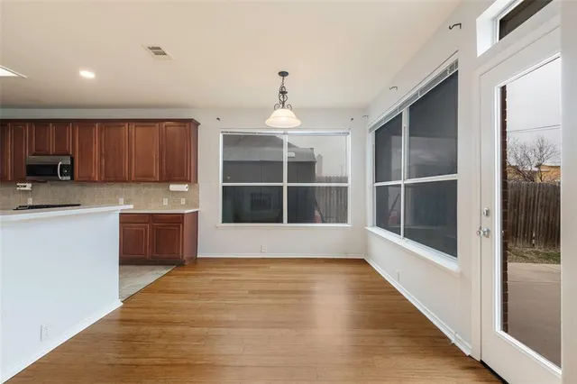 a view of a kitchen with a white kitchen center island and wooden floor
