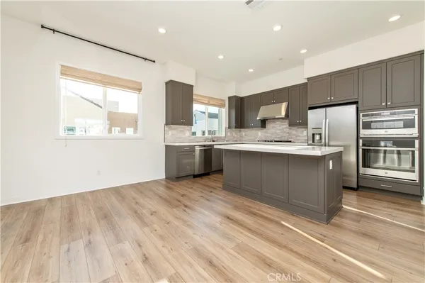 a kitchen with stainless steel appliances granite countertop a stove a sink dishwasher and a refrigerator