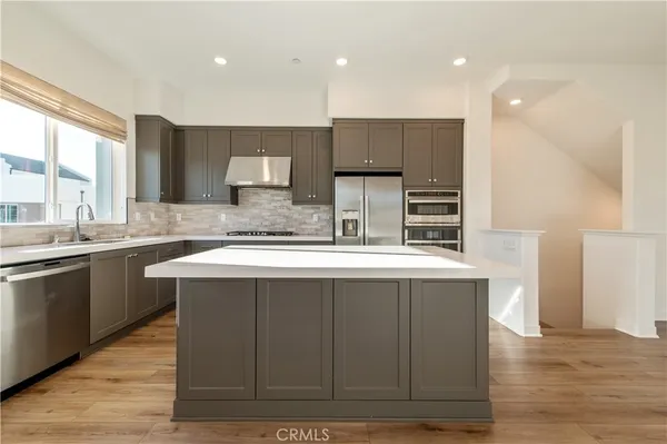 a kitchen with a sink cabinets and wooden floor