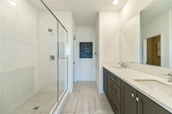 a bathroom with a granite countertop sink a mirror and a shower