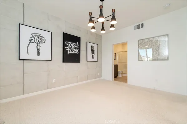 a view of an empty room with a chandelier fan