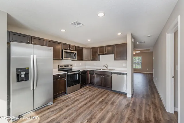 a large kitchen with a refrigerator and a stove top oven