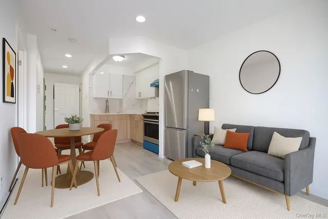 a living room with furniture kitchen view and a wooden floor