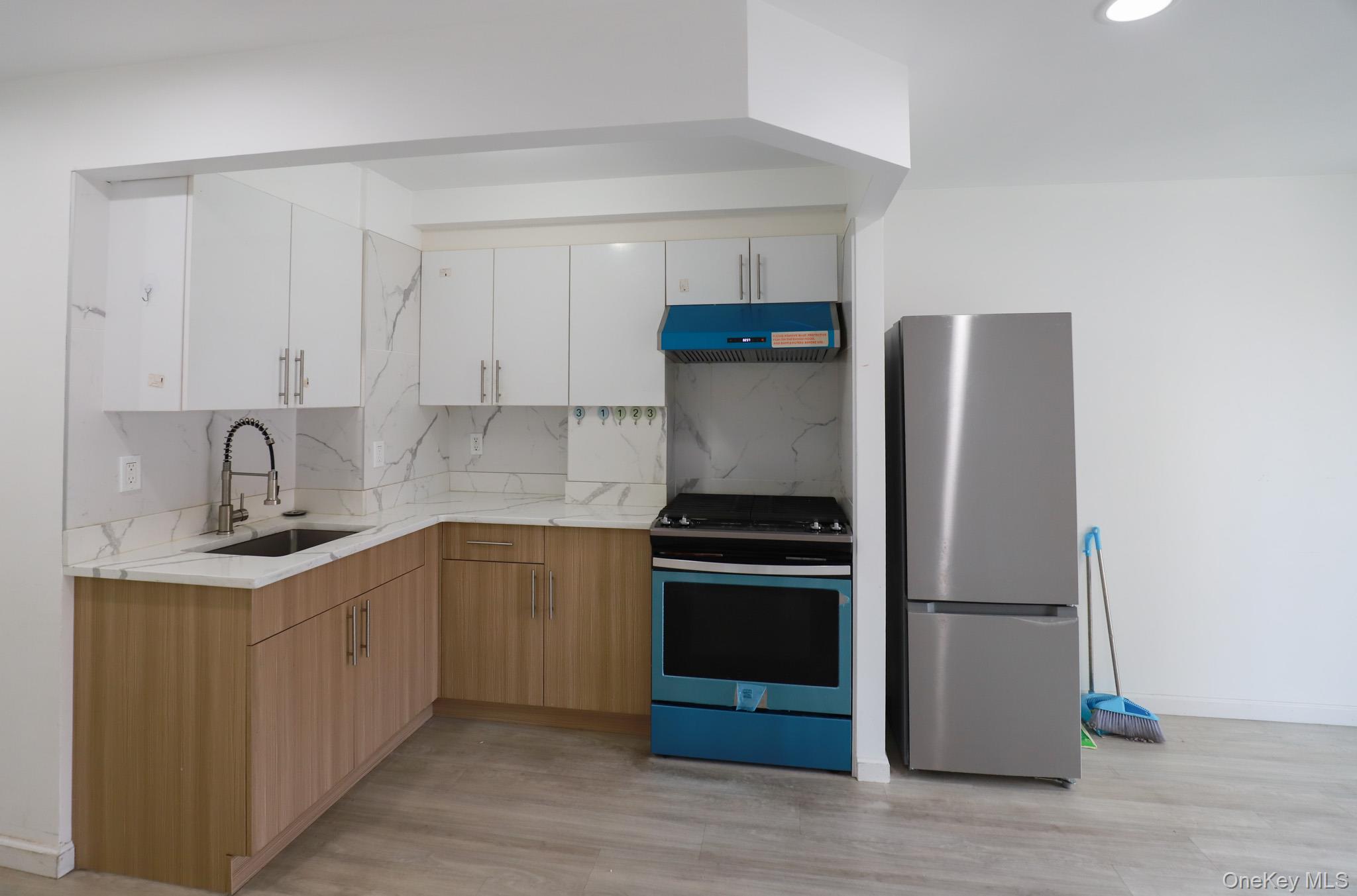 134-43 Maple Avenue, Unit 5B Queens, NY 11355 - Photo 3 of 13 a kitchen with stainless steel appliances a refrigerator and a sink