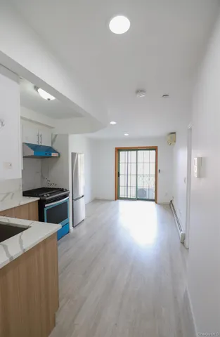 a kitchen with a stove wooden floor and a window