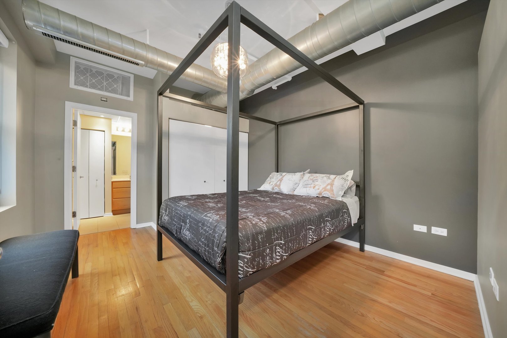 6 East Monroe Street, Unit 1501 Chicago, IL 60603 - Photo 13 of 27 a bedroom with a bed and wooden floor