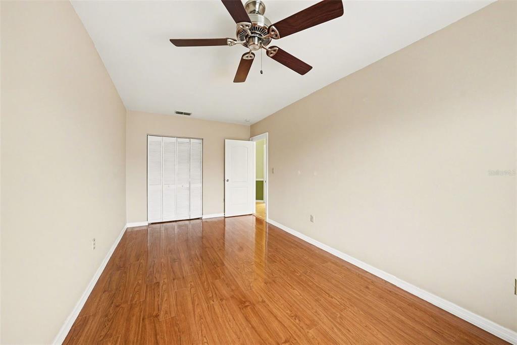 6225 Bayside Drive New Port Richey, FL 34652 - Photo 10 of 31 an empty room with wooden floor ceiling fan and windows