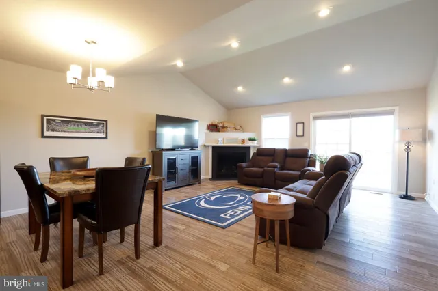 a living room with furniture a chandelier a dining table and wooden floor