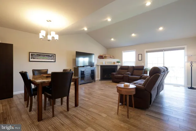 a living room with furniture a dining table and a bookshelf