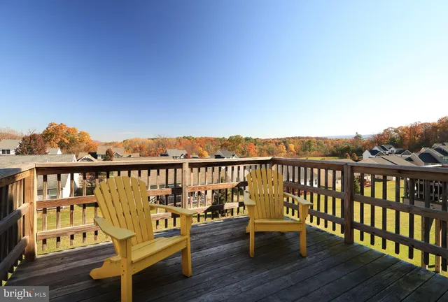 a view of a balcony with wooden chairs