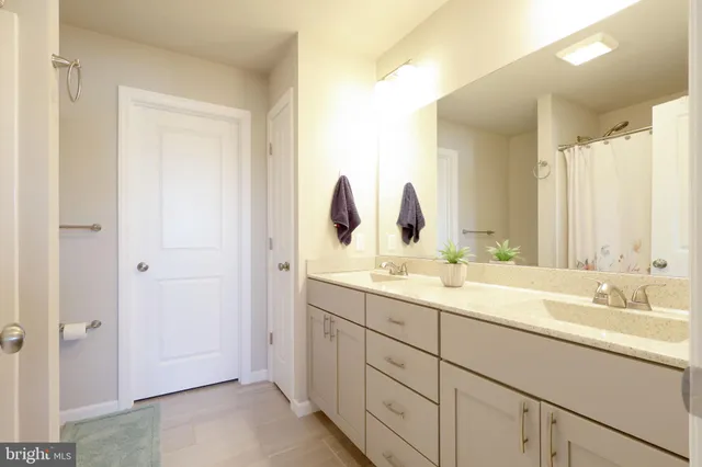 a bathroom with a double vanity sink and mirror