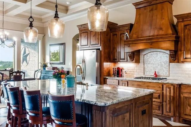 a kitchen with stainless steel appliances kitchen island granite countertop a table chairs in it and wooden floors