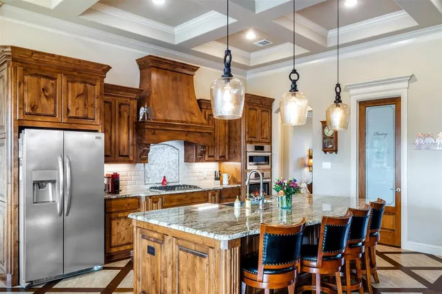 a kitchen with stainless steel appliances kitchen island granite countertop a refrigerator a stove and a dining table with wooden floor