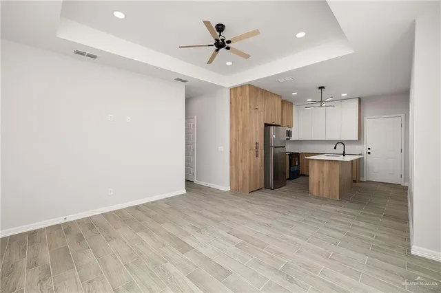 a view of a kitchen with a sink and a refrigerator