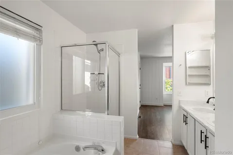 a bathroom with a bathtub shower sink and mirror
