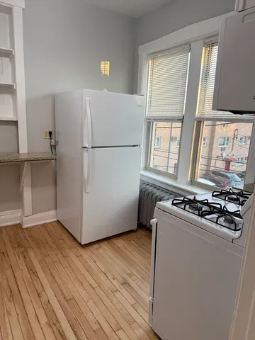 a room with wooden floor and white appliances