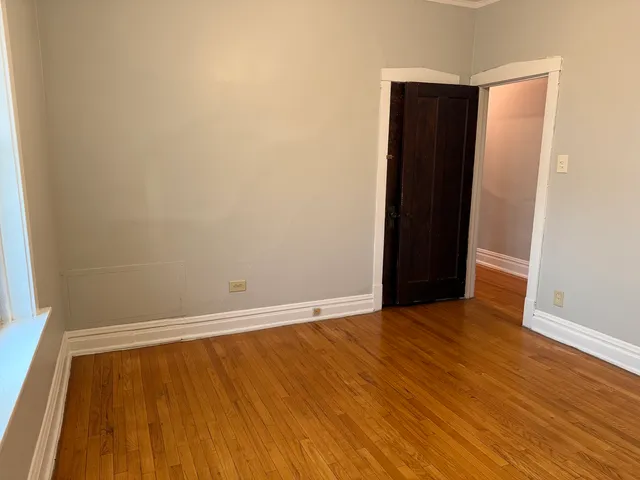 an empty room with wooden floor and closet
