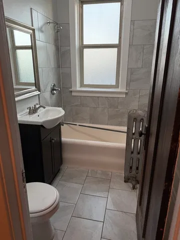 a bathroom with a sink a toilet a mirror and shower