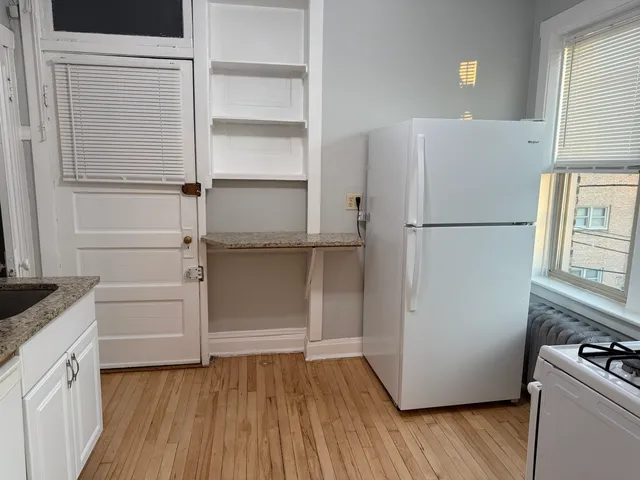 a white refrigerator freezer and a wooden floor