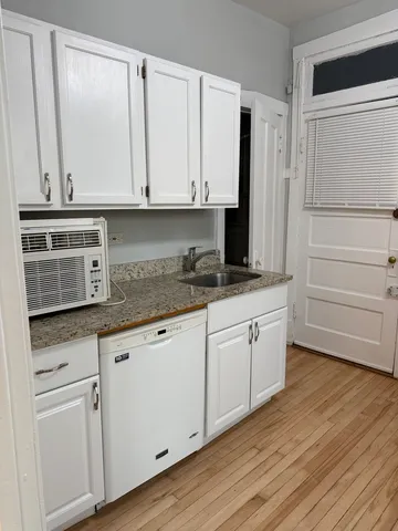 a kitchen with granite countertop white cabinets and sink