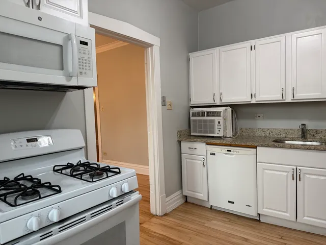 a kitchen with white cabinets and appliances