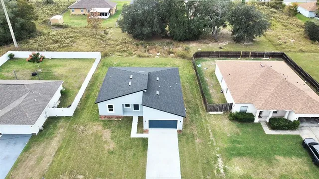an aerial view of a house with a yard