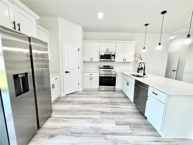a kitchen with stainless steel appliances a refrigerator sink and stove