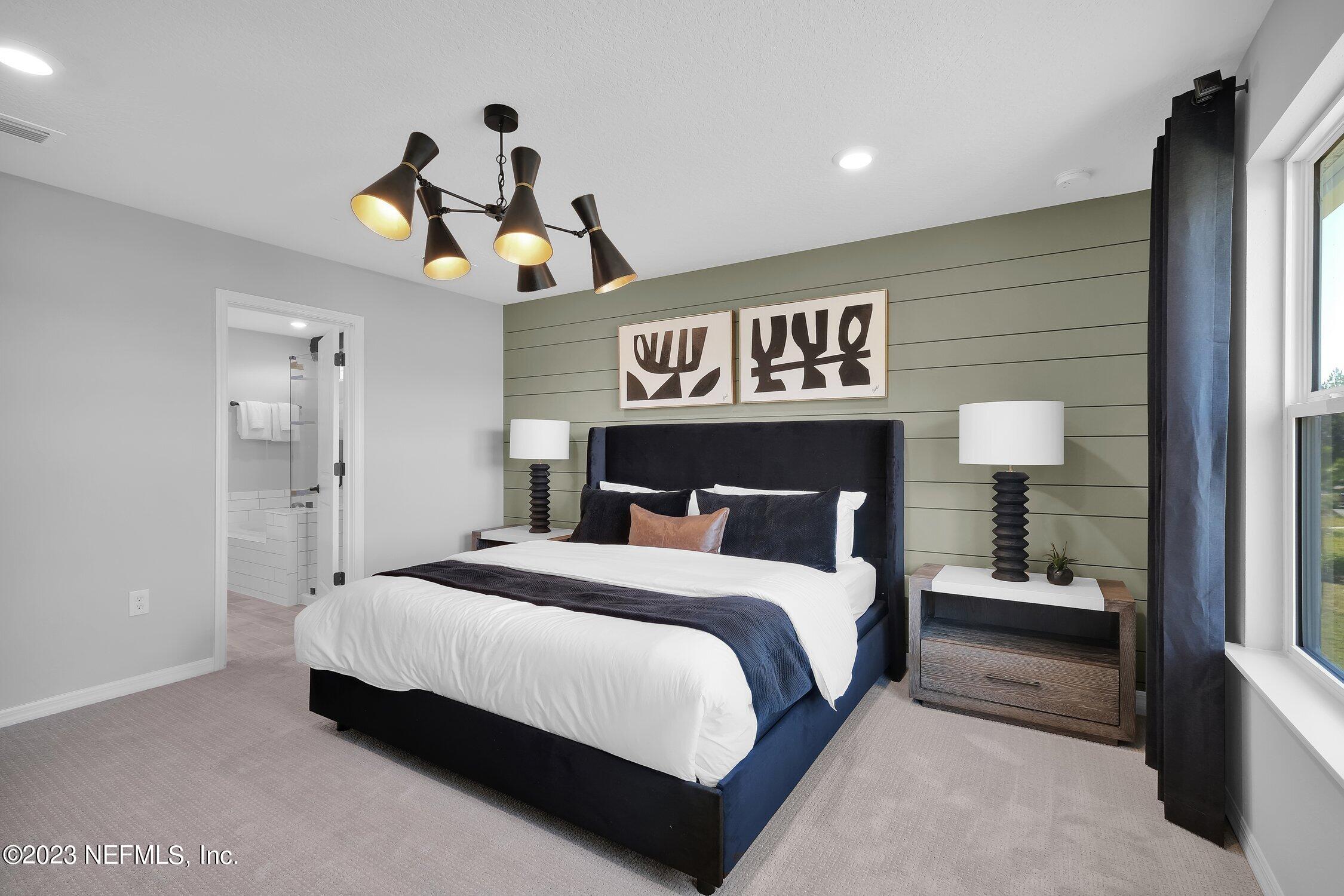 731 Blind Oak Circle St. Augustine, FL 32095 - Photo 16 of 34 a bedroom with a bed and a lamp on table