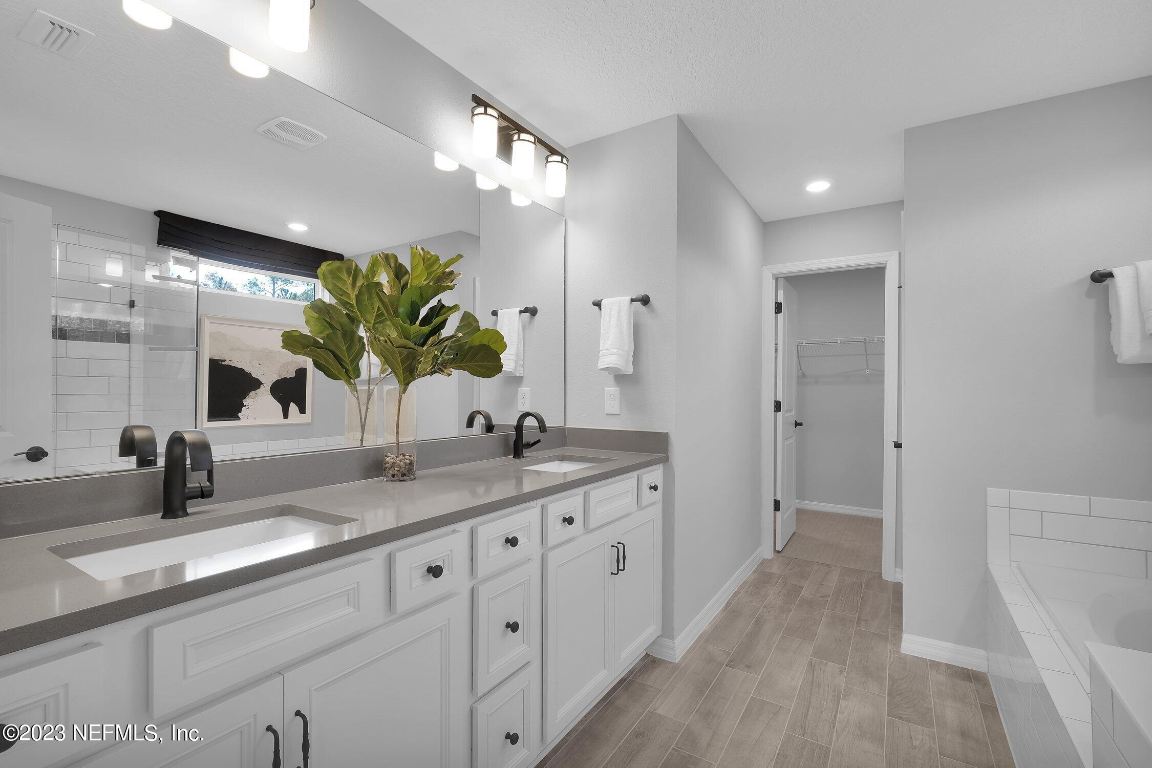 731 Blind Oak Circle St. Augustine, FL 32095 - Photo 17 of 34 a bathroom with a granite countertop sink mirror and a shower