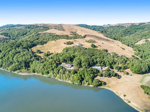 an aerial view of mountain with residential house in the background