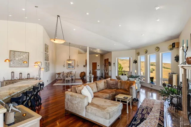 a living room with furniture kitchen view and a large window