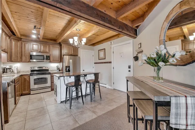 a kitchen with table chairs stainless steel appliances and cabinets
