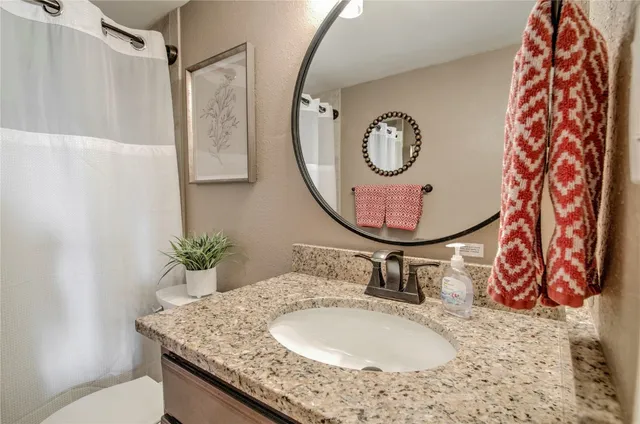 a bathroom with a granite countertop sink mirror and vanity