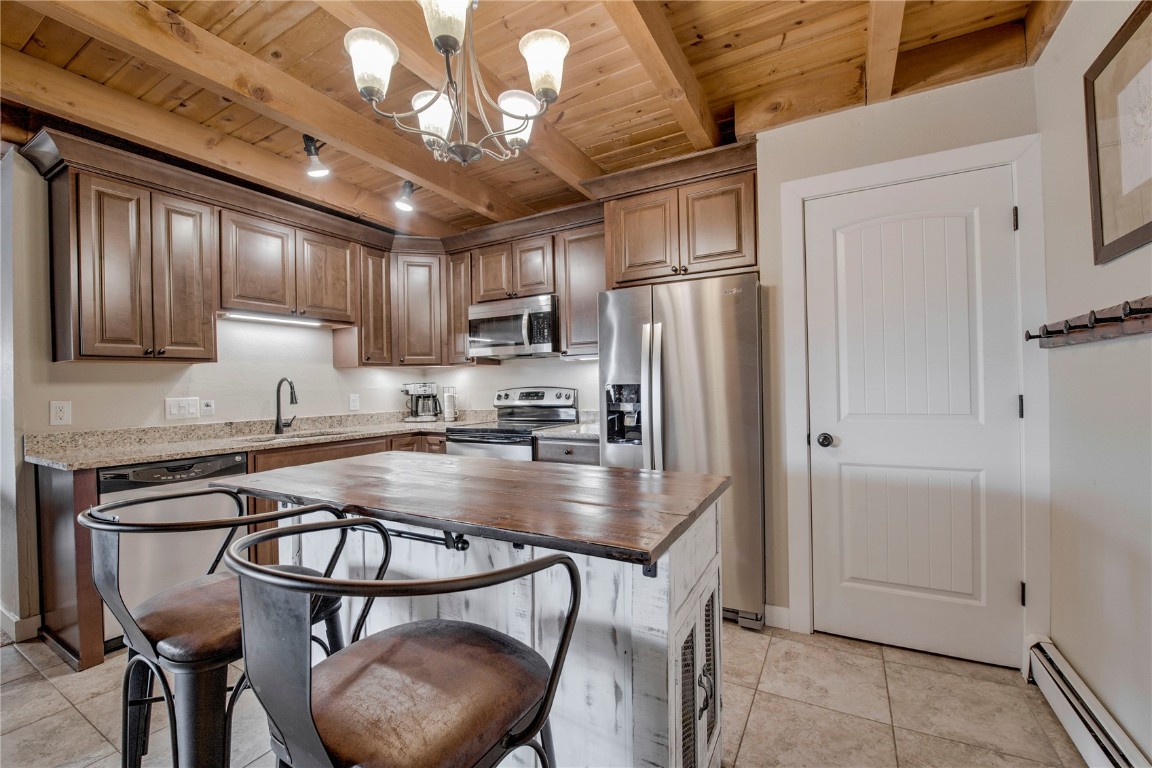 8500 Ryan Gulch Road, Unit G3 Silverthorne, CO 80498 - Photo 7 of 28 a kitchen with stainless steel appliances granite countertop a table chairs refrigerator and cabinets