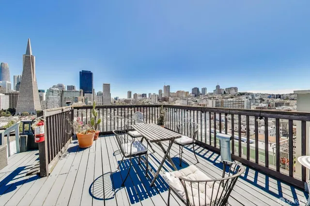 a view of a balcony with chairs and wooden floor