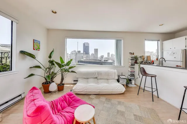 a white bed sitting in a spacious bedroom next to a window