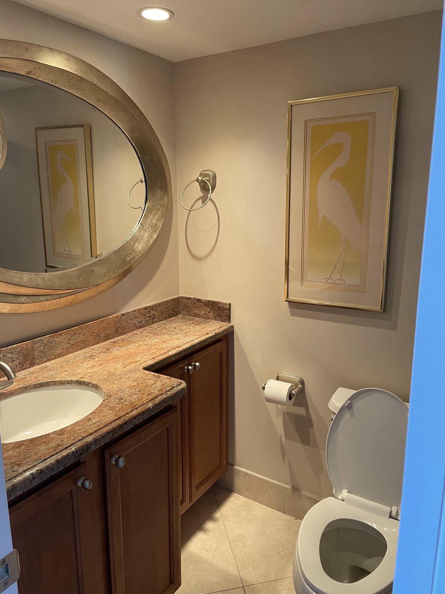 3000 North Ocean Drive, Unit 36C Riviera Beach, FL 33404 - Photo 7 of 18 a bathroom with a granite countertop toilet sink and mirror