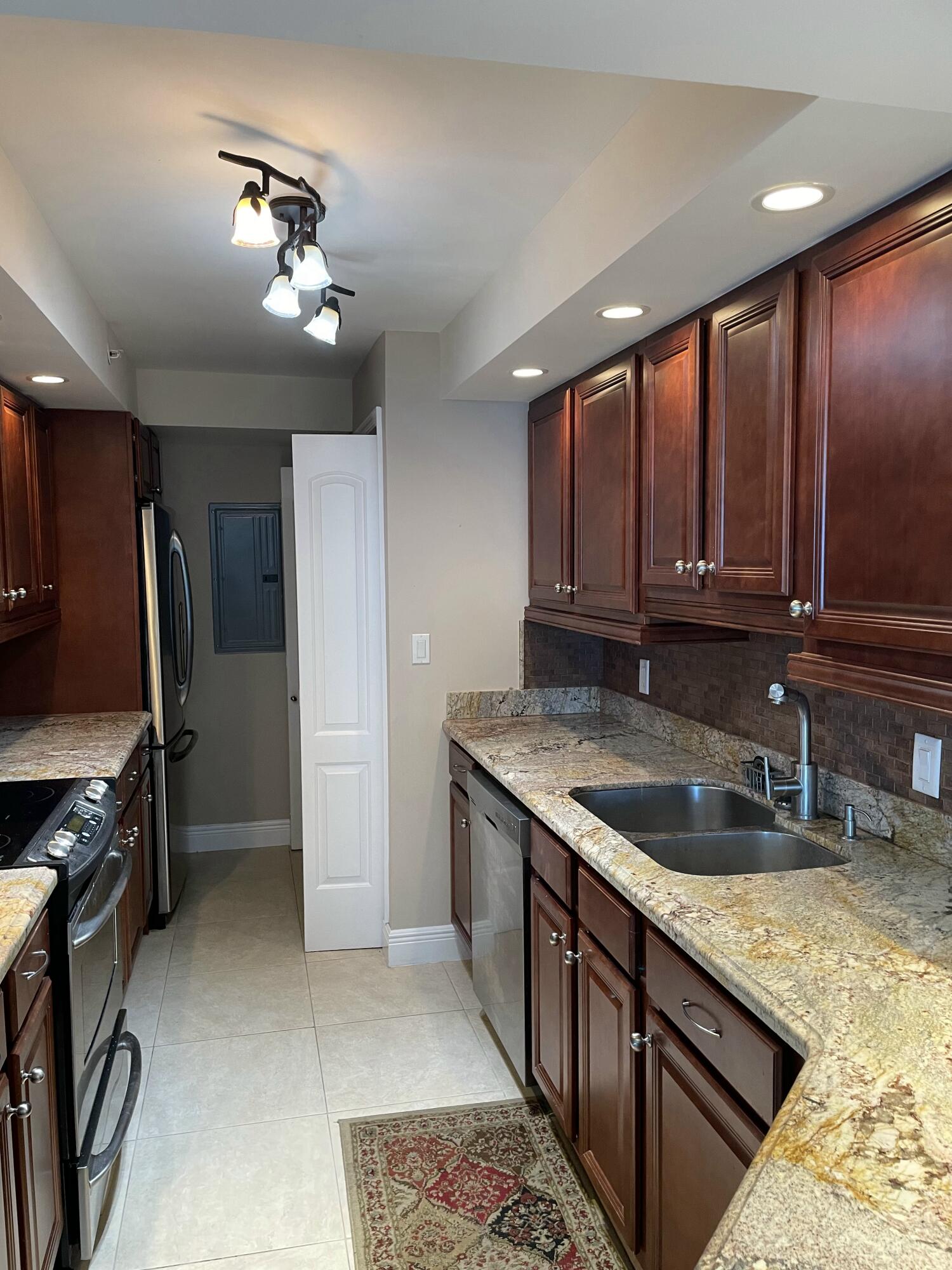 3000 North Ocean Drive, Unit 36C Riviera Beach, FL 33404 - Photo 8 of 18 a kitchen with stainless steel appliances granite countertop a sink stove and refrigerator