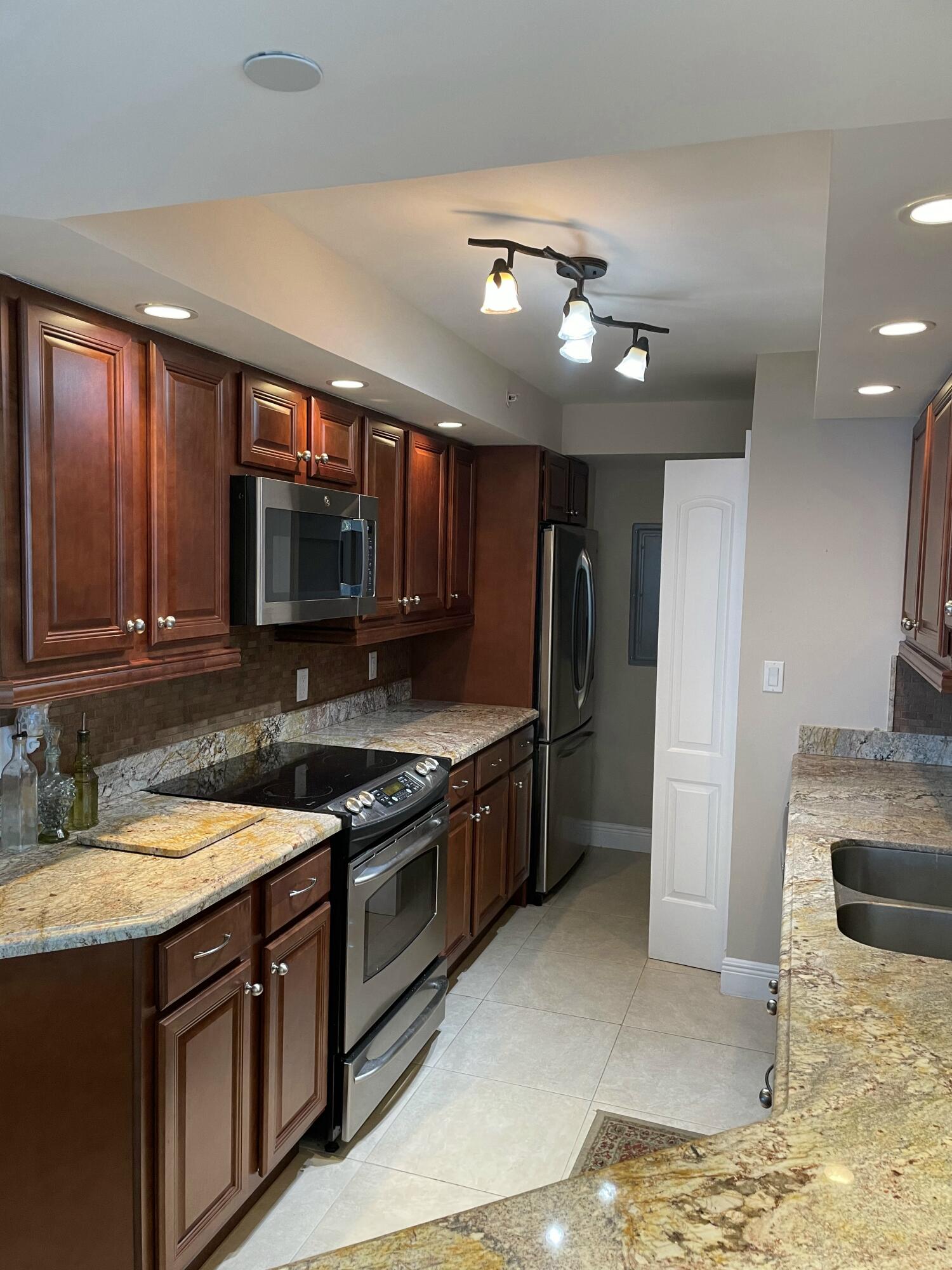 3000 North Ocean Drive, Unit 36C Riviera Beach, FL 33404 - Photo 9 of 18 a kitchen with stainless steel appliances granite countertop a sink and a stove