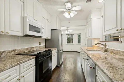 a kitchen with stainless steel appliances granite countertop a sink stove and cabinets