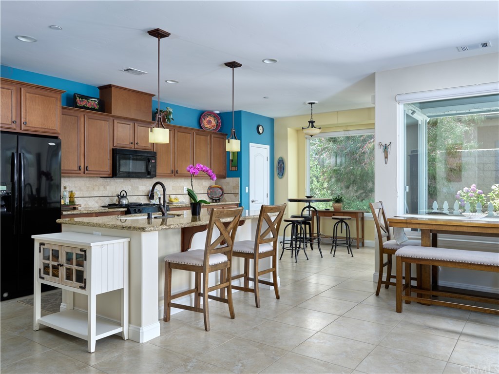 1156 Saltillo Way Nipomo, CA 93444 - Photo 6 of 29 a kitchen with stainless steel appliances granite countertop a table and chairs