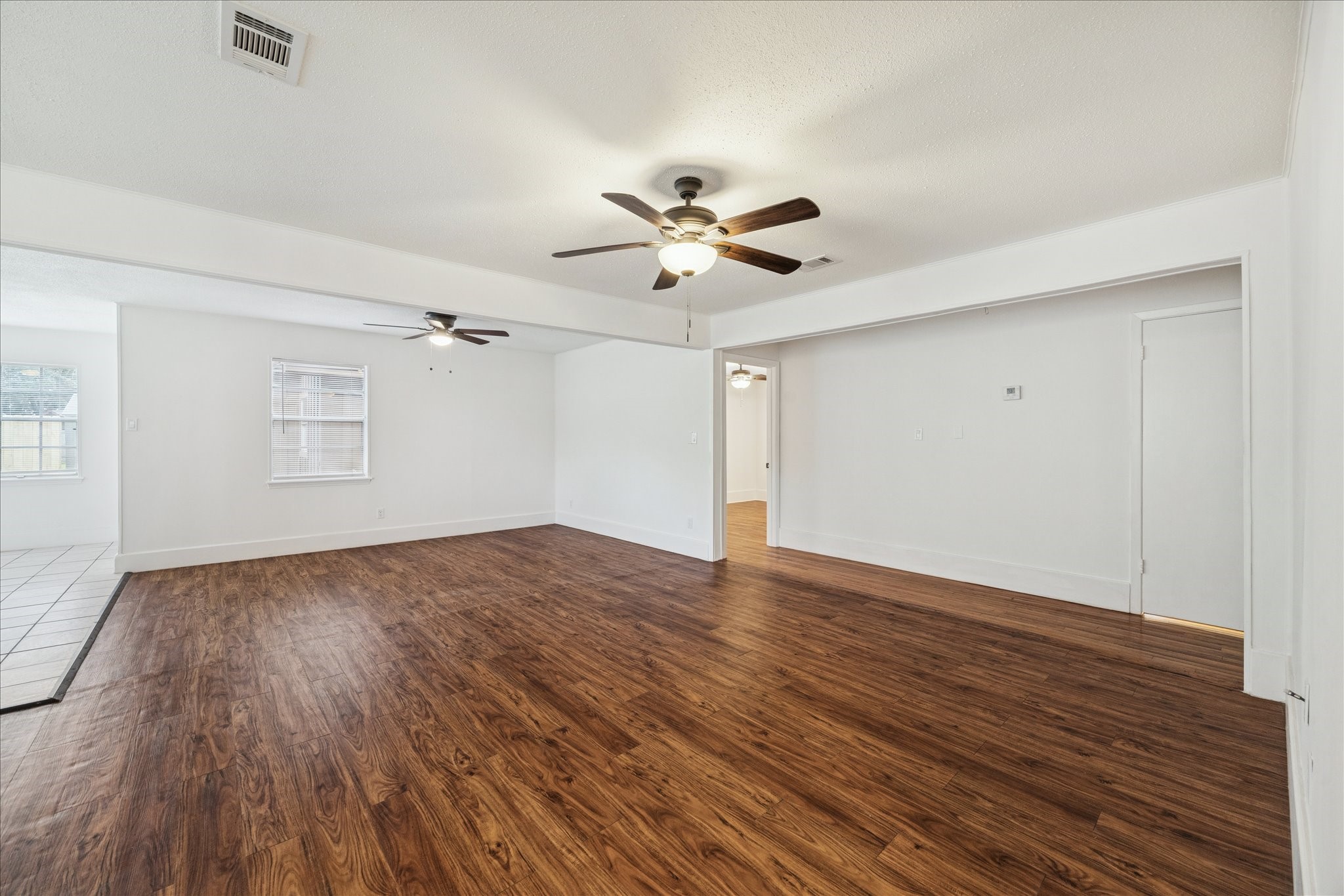 431 Hummingbird Lane Houston, TX 77060 - Photo 12 of 22 an empty room with wooden floor and ceiling fan