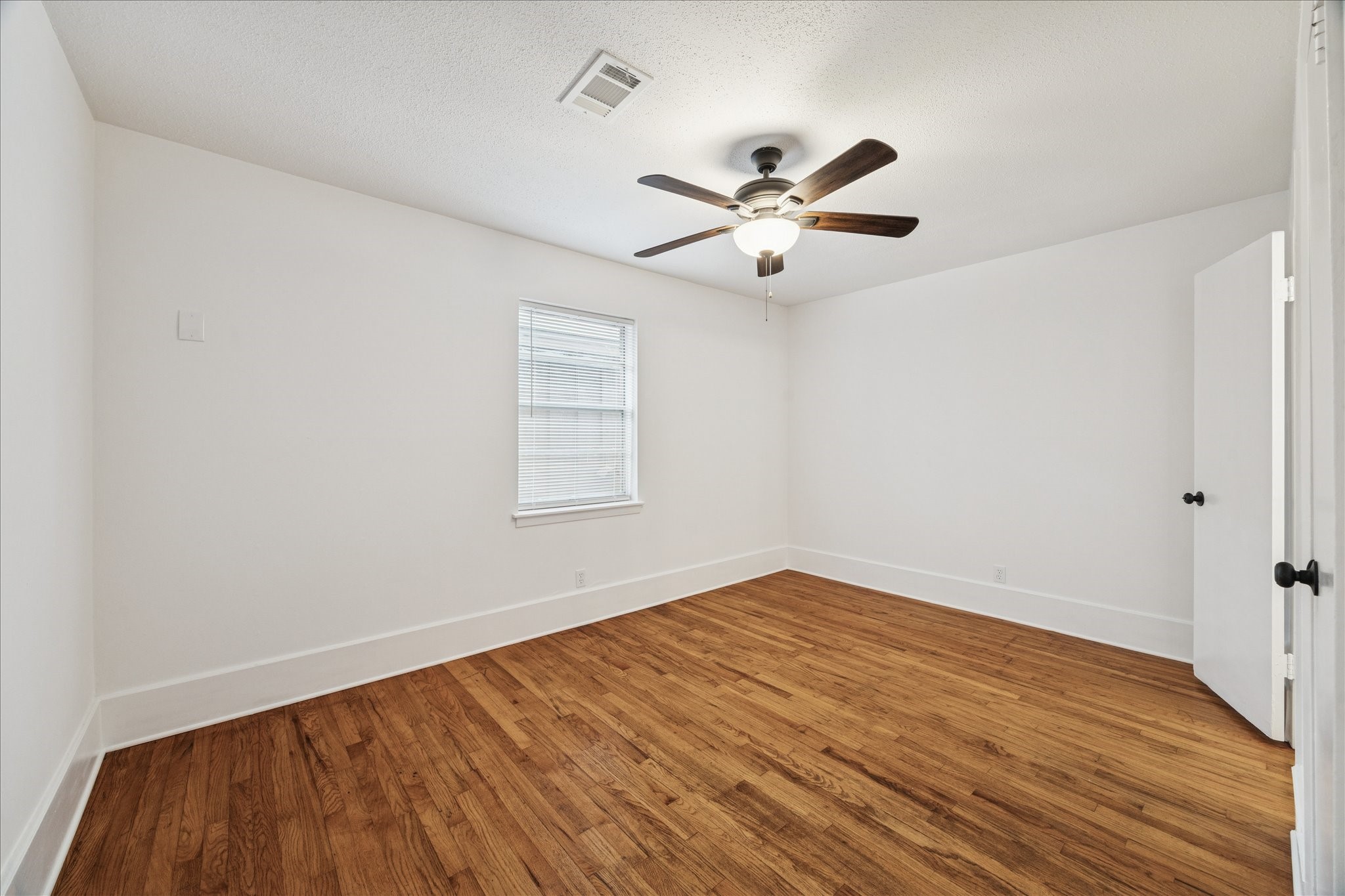 431 Hummingbird Lane Houston, TX 77060 - Photo 16 of 22 an empty room with wooden floor fan and windows