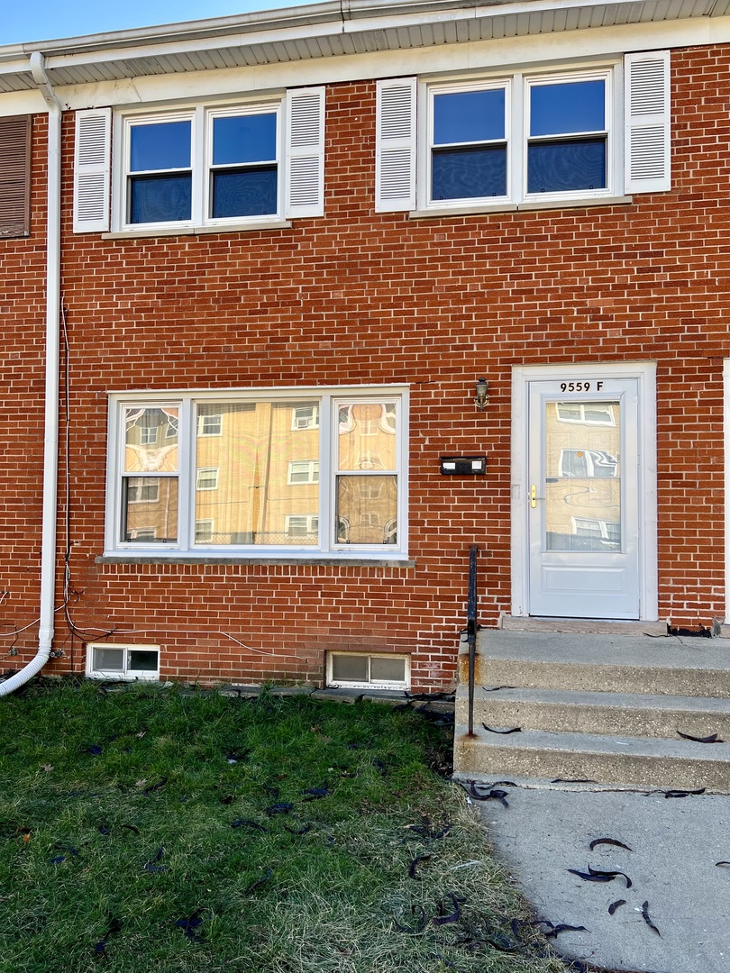 9559 Sumac Road, Unit F Des Plaines, IL 60016 - Photo 1 of 24 a front view of a house with a yard