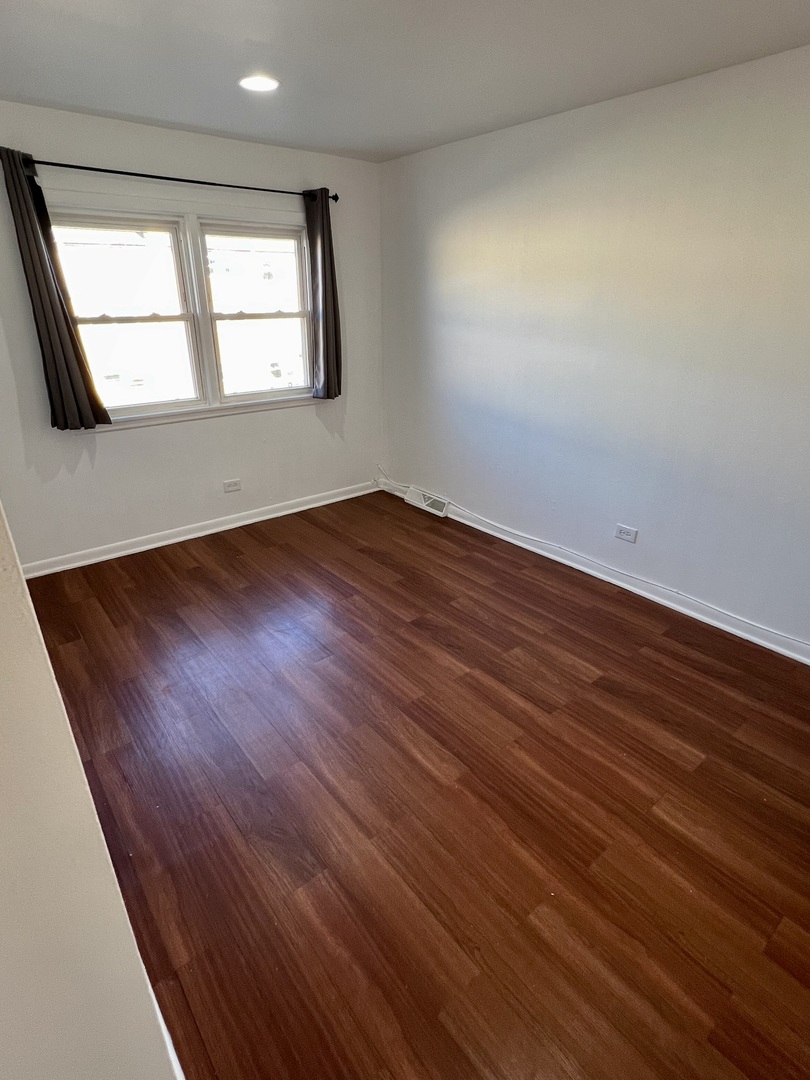 9559 Sumac Road, Unit F Des Plaines, IL 60016 - Photo 14 of 24 an empty room with wooden floor and windows